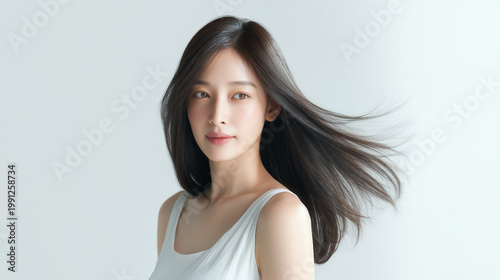 風に流れる美しい艶やかな黒髪を持つ日本人女性：ヘアケア・美容広告・美容院向け	