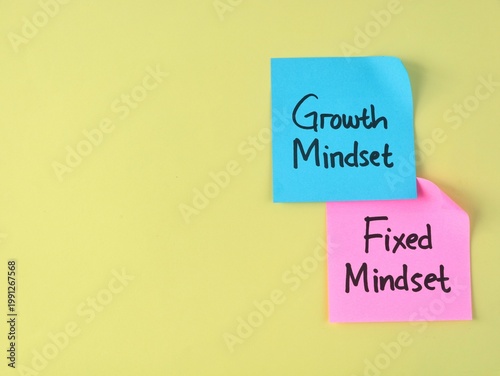 Growth mindset and fixed mindset text on adhesive notes on yellow background. Represents personal development, educational psychology, business strategy, and the choice between self-improvement