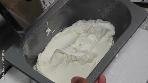 Ice cream maker machine. Ice cream falls into container.