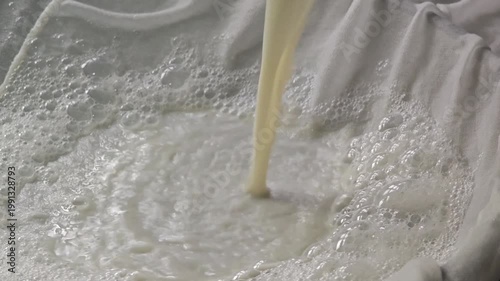 Soy milk filtering by white clothes, before boiling.