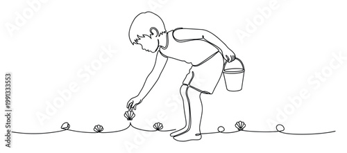 Young child collecting seashells with bucket on beach, depicting summer activity and holiday play