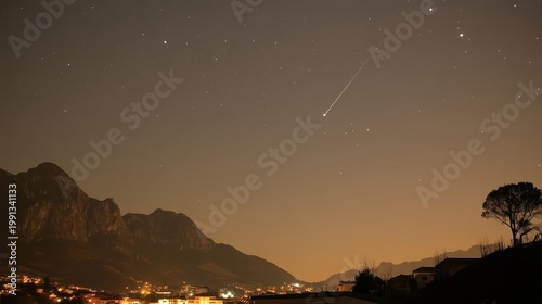 A Brilliant Meteor Streaks Across the Dark Night Sky Above a Silhouetted Mountain Range and Illuminated Townscape