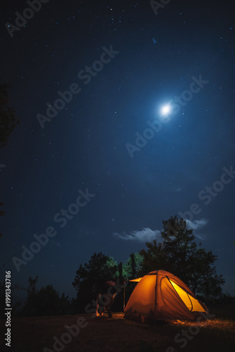 nature traveling with orange camping tent on mountain with milky way and star background