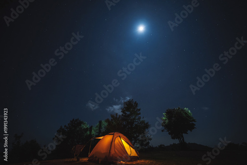 nature traveling with orange camping tent on mountain with milky way and star background