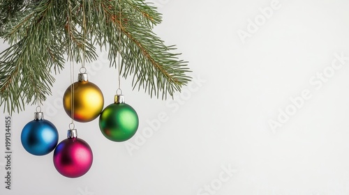 Festive Christmas Ornaments Hanging on a Pine Branch with Soft Lighting