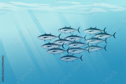 School of tuna fish swimming underwater with sunlight rays shining through ocean waves