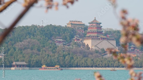 Beautiful panoramic view of ancient Chinese architecture at Summer Palace with traditional boat on the water and historic pavilion on the hill during spring season in Beijing