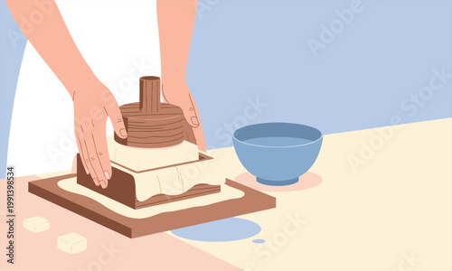 Hands pressing fresh cheese using a wooden mold on a table