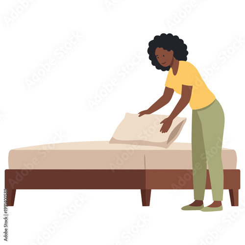 A woman is making a bed with a pillow and sheet indoors