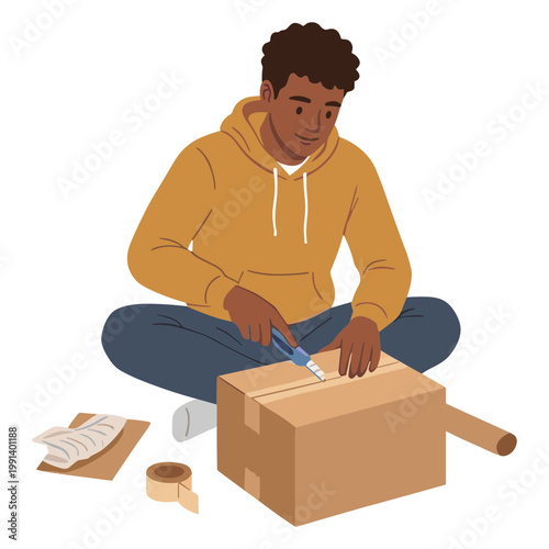 A man sits on floor cutting cardboard box with knife and tape