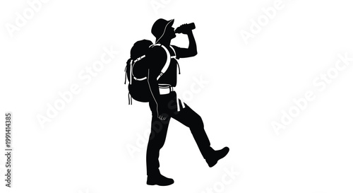Silhouette of a hiker drinking from a water bottle while walking