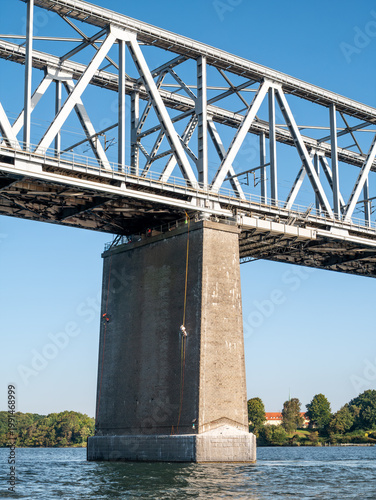 Workers on bridge pier of Old Little Belt Bridge from water near Snoghøj, Jutland, Little Belt strait, Southern Denmark