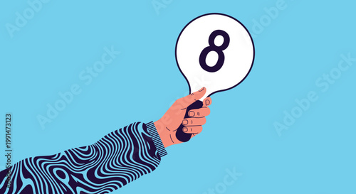 Close up of a hand in a patterned sweater holding a round white score card with the number eight for judging or performance evaluation.