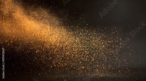 Abstract golden glitter particles floating against a dark background