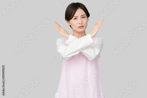 両手でバツ印を作るエプロン姿の女性（禁止・拒絶・NGイメージ）