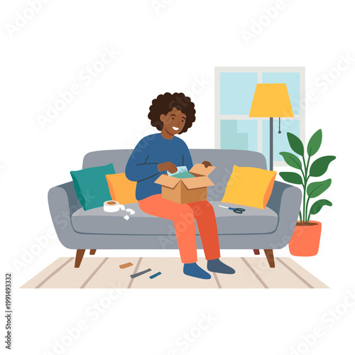 Woman sitting on sofa unpacking a box with a happy expression