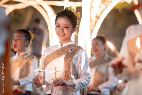 Young Woman in Traditional Dress Holding Candles at Festival Celebration