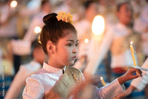 Young Girl in Traditional Attire Holding Candle During Festival Ceremony