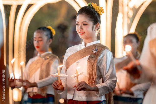 Beautiful young woman with candle in traditional Asian festival attire