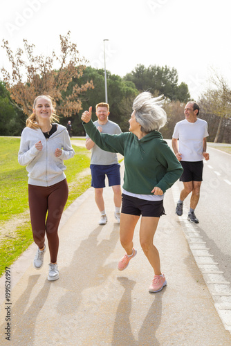 Фотография Happy multi generational group giving thumbs up jogging