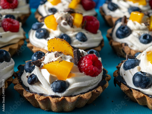 Quadro su tela Sweet, crispy cupcakes filled with cream and colorful fruit for a party