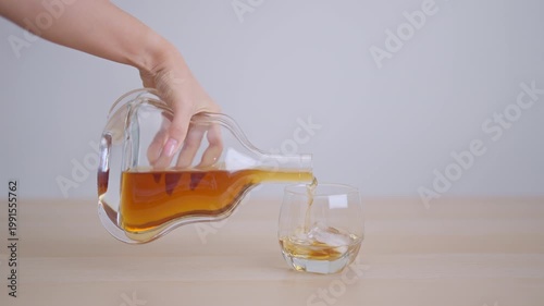 man pour cognac into a glass on table, suffering from alcohol addiction, alcoholism concept. depicting emotional distress, depression, substance abuse problem, unhealthy lifestyle and mental health