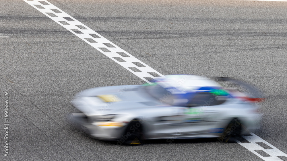 Fototapeta premium Motion blur, Race car racing on speed track, race car on road crossing start and finish line, Target business achieve and victory concept.
