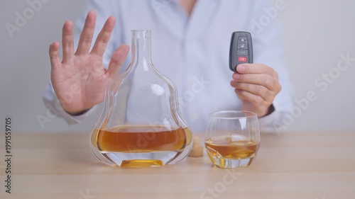 Responsible man reject a drink before driving for road safety, Man making stop hand gesture to refuse a glass of whiskey and car remote. Avoid drink and drive, Drunk Driving Law concept