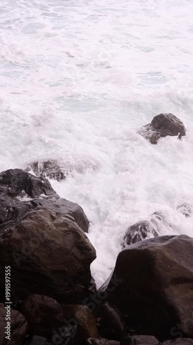 Powerful white foamy Atlantic ocean waves crashing over dark volcanic rocks in Tenerife, Canary Islands. Perfect for nature, environment, travel and cinematic background projects.