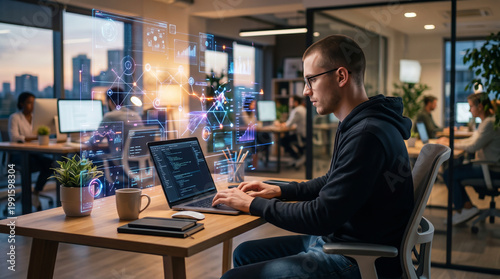 Software developer coding on laptop with holographic data interface in modern office. Artificial intelligence, programming, data analytics, digital innovation, and technology workspace concept.