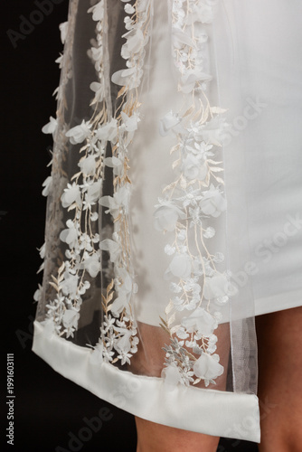 Cuadro en lienzo Bottom edge detail of a bridal tulle cape with white 3D flower decorations