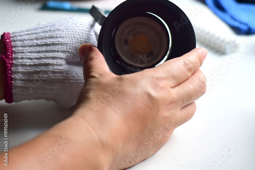 The electrician is removing and reassembling the light bulb.