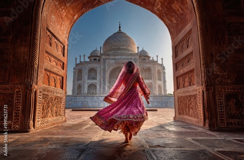 A woman in a vibrant red and pink dress gracefully dances through an archway, with the iconic Taj Mahal majestically framed in the background, bathed in warm sunlight.