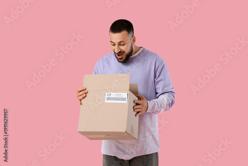 Young man unpacking parcel ...