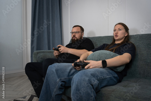 Cuadro en lienzo Young couple enjoying leisure time at home, concentrating on their game controll
