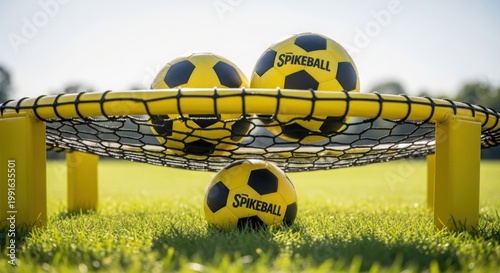 Soccer balls on yellow goal in green grass field. Soccer balls are positioned inside the yellow goal, showcasing vibrant colors and a sunny day.