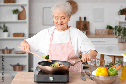 Senior woman frying food in kitchen