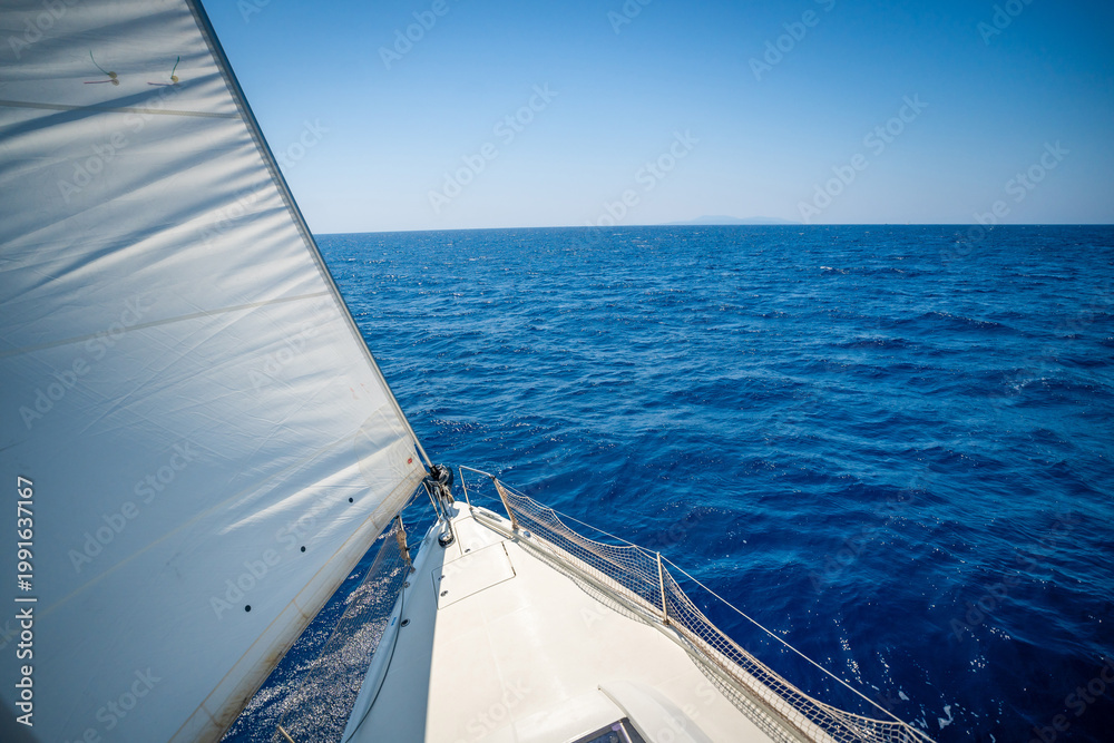 Obraz premium View from the mast down to the bow of a sailing yacht moving under full sails near Croatia. Freedom, adventure, yachting lifestyle and dynamic sea travel.