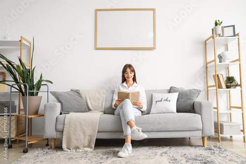 Young woman reading book on...
