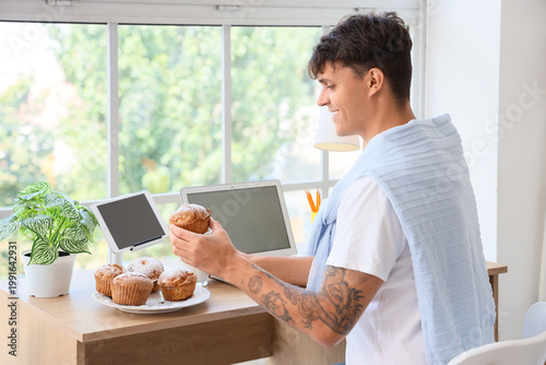 Young man with tasty muffin...