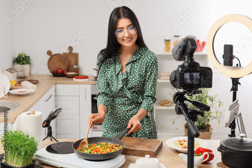Young woman frying vegetabl...