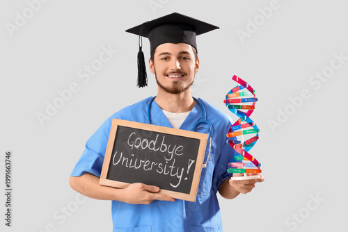 Male medical graduate student holding chalkboard with text GOODBYE UNIVERSITY...