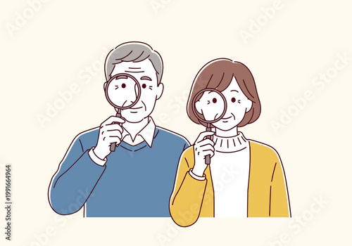Senior couple looking through magnifying glasses