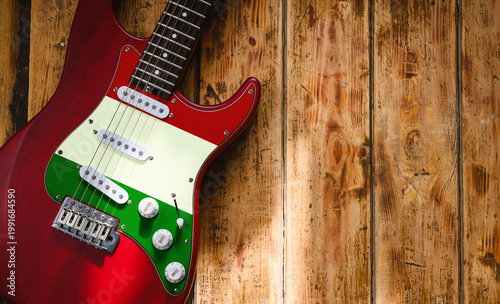 Electric guitar with the Italian flag on a vintage wooden background. Copy space