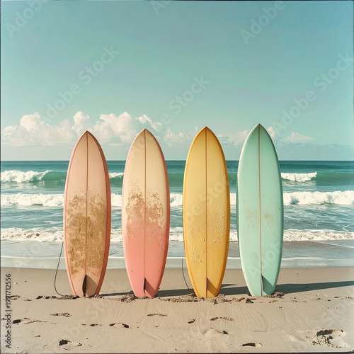 Four surfboards on a sunny beach with waves