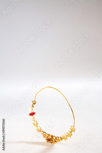 Foto golden nose ring on a white background