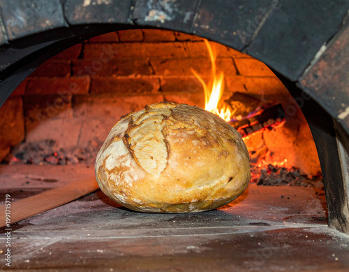 Fresh baked bread smoking on rustic wooden background, artisanal food photography