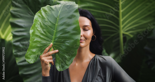 Radiant Tanned Woman With Leaf Covering Face, Natural Skincare Portrait