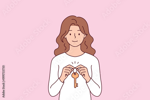 Young woman showing apartment key. Concept of buying new home, selling property, moving in, or renting house. Real estate mortgage and investment.