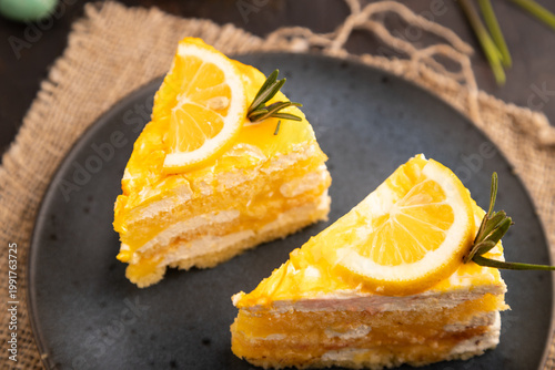 Lemon cake on black concrete, linen textile, cup of coffee, side view, close up, selective focus